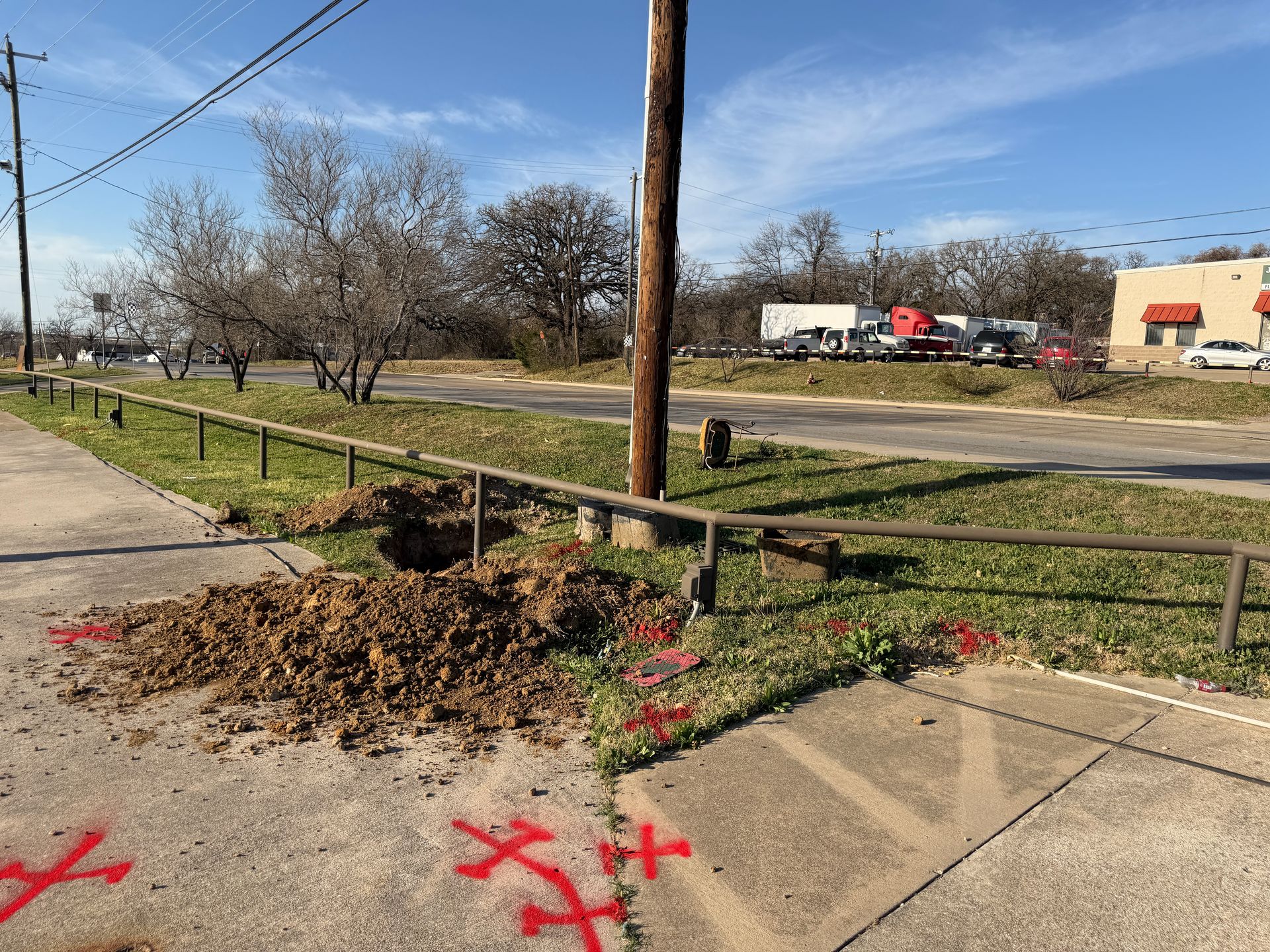 Paint-marked utility locations along a Texas roadside site