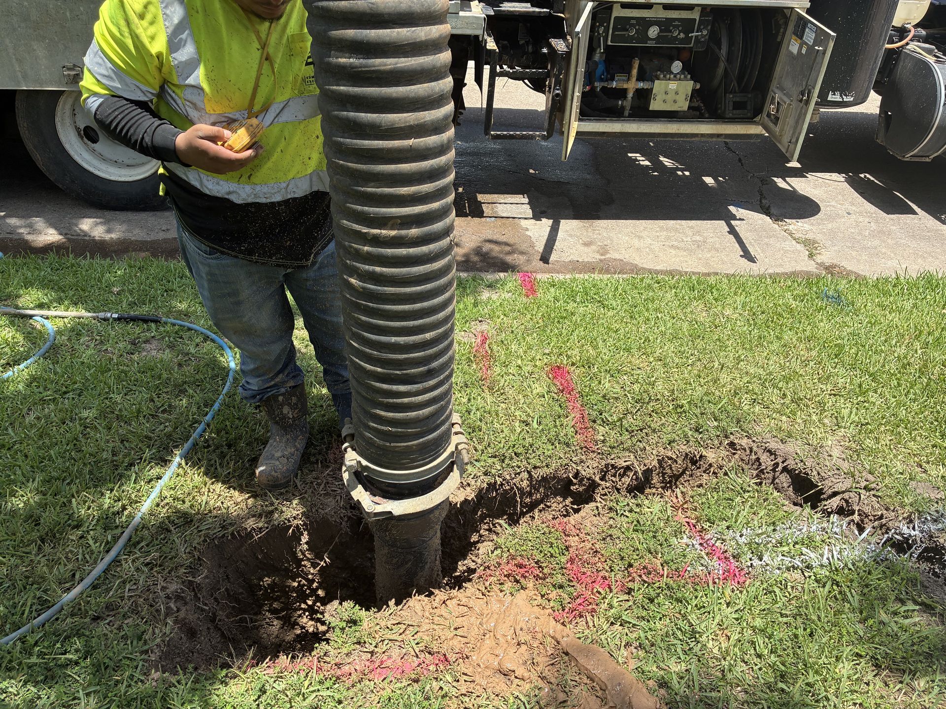 Vacuum excavation hose potholing at a marked utility location